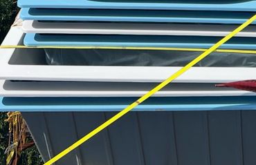 Stack of blue and white panels strapped with yellow bands.