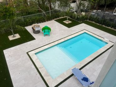 Modern backyard with a rectangular pool and seating area.