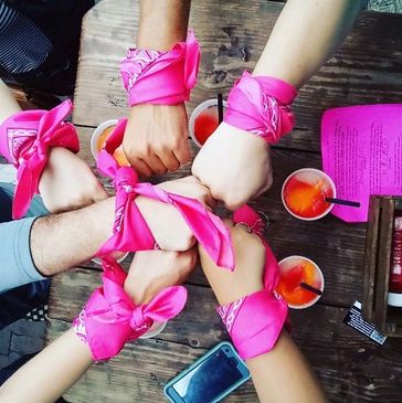 Group of hands with color team bandannas