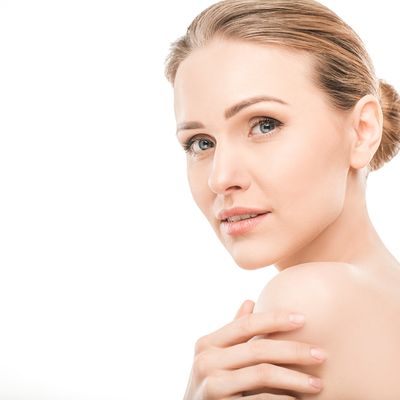 A pretty lady touching her soft skin after using PoShun head to toe body oil.