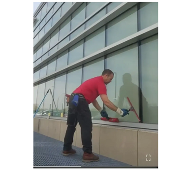 Man cleaning large windows of a modern building.