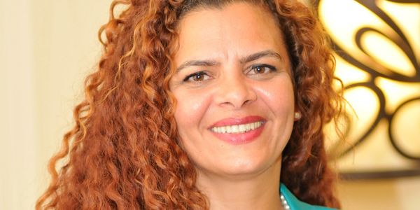 Smiling woman with curly red hair.