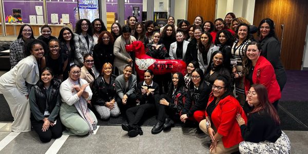 Large group of smiling women posing indoors.