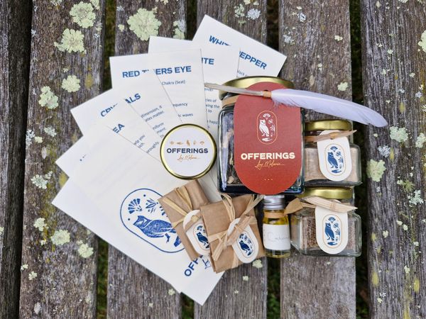 A collection of herbal offerings and natural products on a wooden surface.