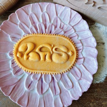 Freshly cut pasta with intricate design on a pink floral plate.