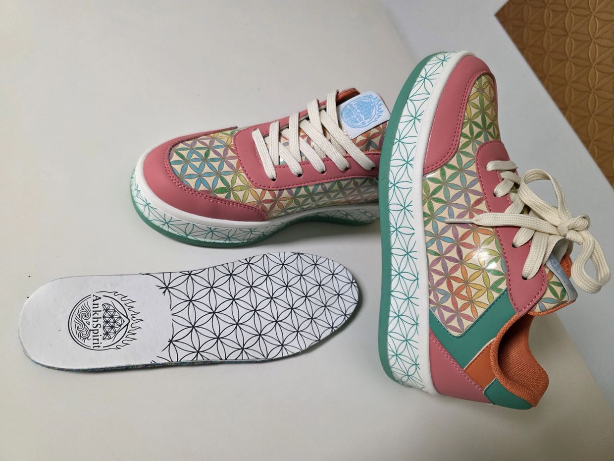Colorful patterned sneakers with matching insoles laid on a white surface.