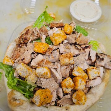 Grilled chicken salad with croutons and dressing on the side.
