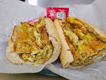 Hearty egg sandwich stuffed in a crusty baguette with ketchup packets.