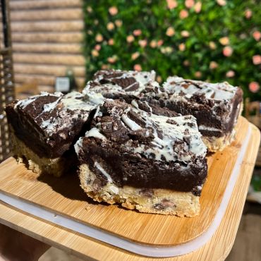 Delicious layered dessert bars with cookie crust, chocolate fudge, and cream topping.