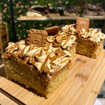 Moist cake squares topped with creamy frosting, caramel drizzle, and a cookie.