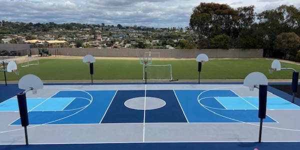 Outdoor basketball courts with multiple hoops and a soccer goal in the background.