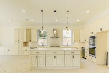 Bright, spacious kitchen with cream cabinets and a large central island.