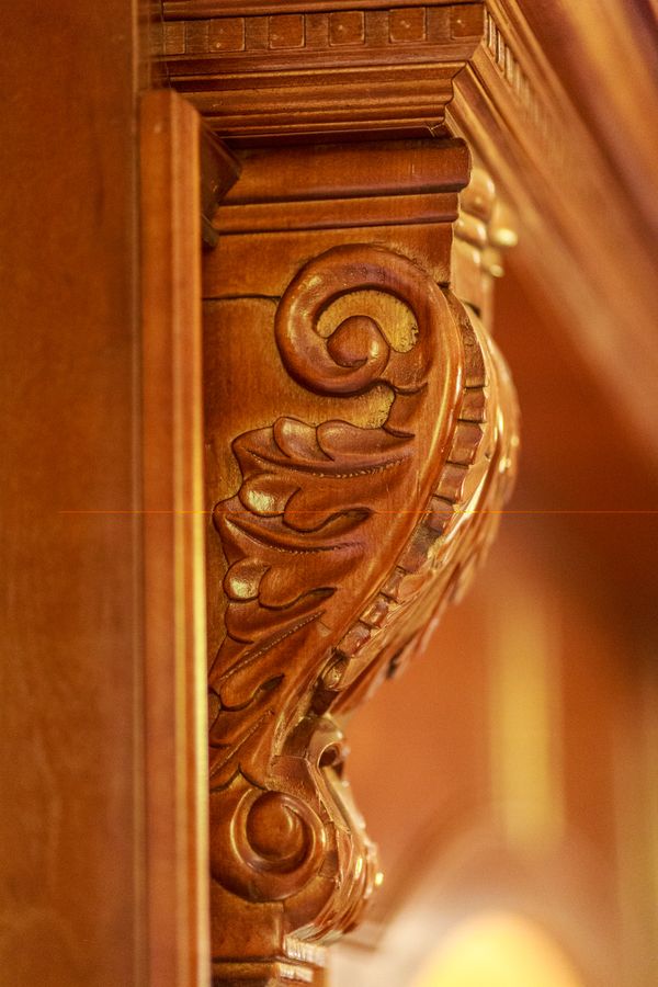 Close-up of intricate wooden carving with scroll and leaf patterns.
