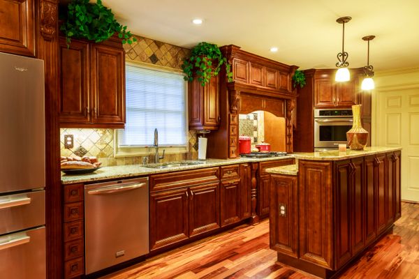 Warm kitchen with rich wooden cabinets and granite countertops.