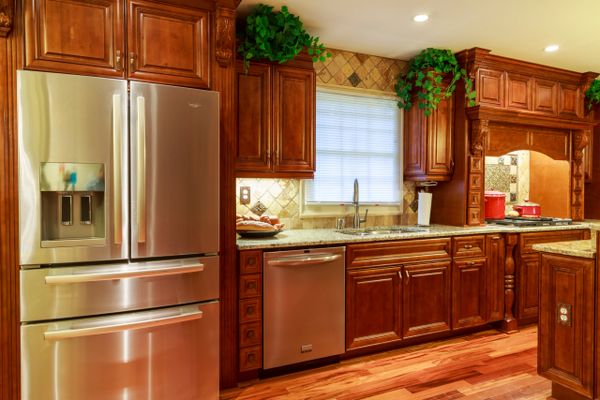 Modern kitchen with stainless steel appliances and rich wooden cabinetry.