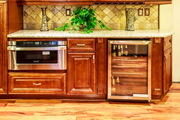 Elegant kitchen cabinetry with stainless steel appliances and a countertop plant.