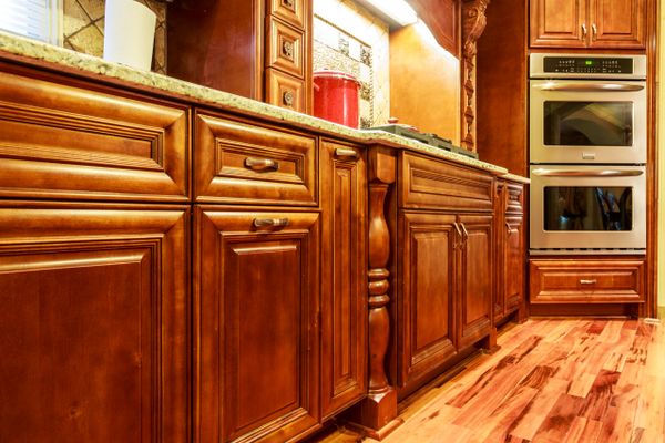 Beautiful kitchen with polished wooden cabinets and stainless steel double oven.