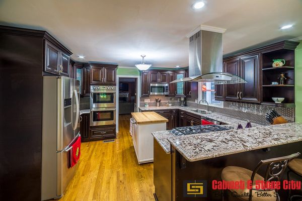 Modern kitchen with dark wood cabinets and granite countertops.