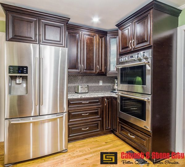 Modern kitchen with stainless steel appliances and dark wood cabinets.