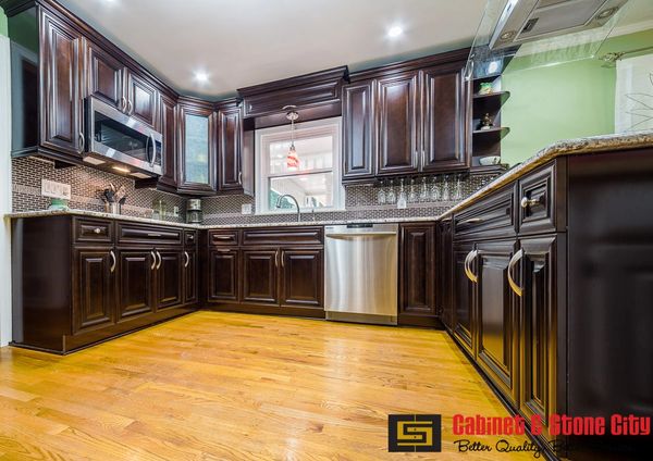 Modern kitchen with dark wood cabinets and stainless steel appliances.