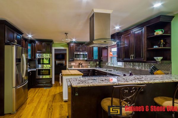 Modern kitchen with dark wood cabinets and granite countertops.