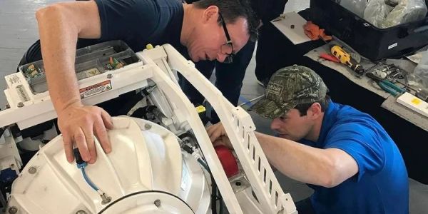 Two men working on a mechanical device.