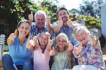 A joyful multi-generational family giving thumbs up outdoors.