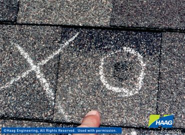 Hail damage to an asphalt roof shingle.