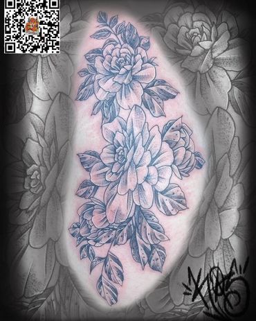 Intricate floral tattoo with detailed shading and leaves.