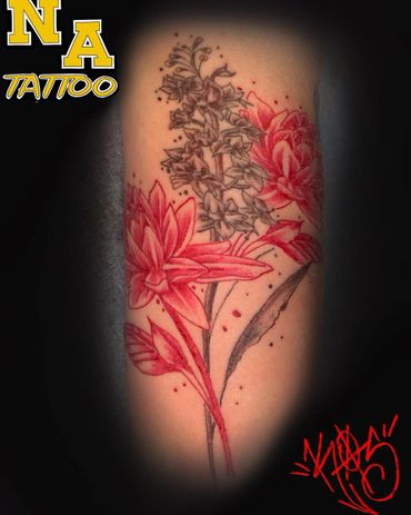 Floral tattoo with red and black ink blending detailed flowers and leaves.