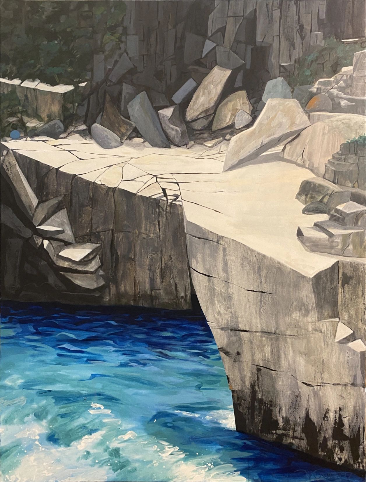 A rocky cliffside overlooking vibrant, blue water below.