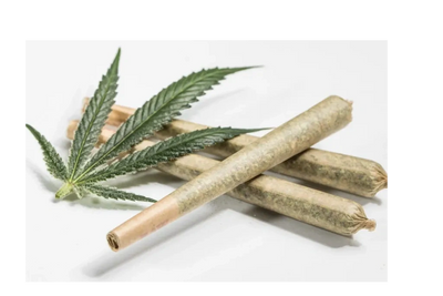 Three rolled cannabis joints with a cannabis leaf on a white background.
