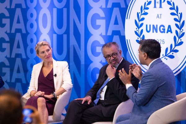 Three people engaged in discussion at UNGA event.