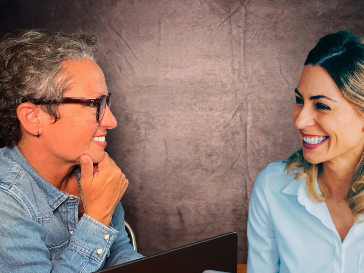 Two women chatting and smiling.
