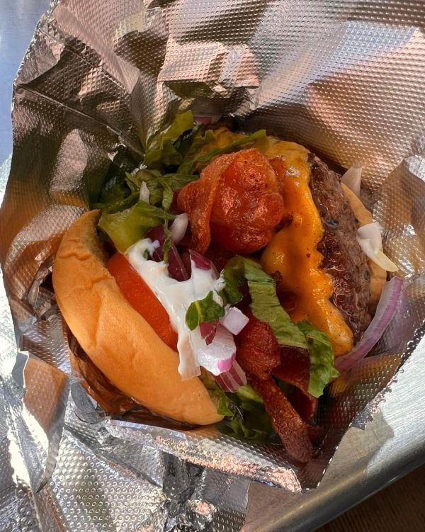 Cheeseburger with bacon, lettuce, tomato, and onions.