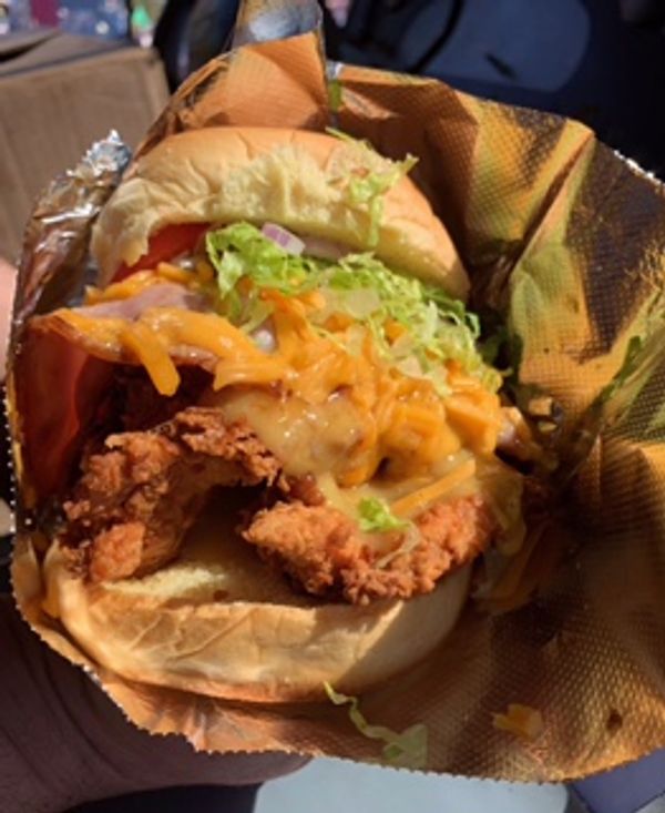 Close-up of a fried chicken sandwich with lettuce and cheese.