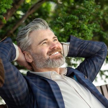 Male with thick gray hair smiling