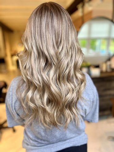 Long, wavy blonde hair cascading down a person's back.