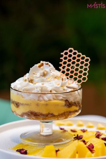 Layered dessert with whipped cream and honeycomb decoration in a glass.
