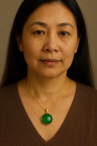 This pendant showcases a beautifully matched round cabochon of fine jadeite, set in a refined 18-kar