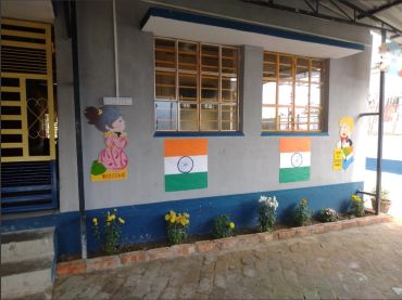 Colorful wall art with Indian flags and welcoming cartoon figures at a school or daycare.