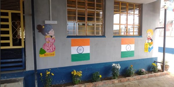 Colorful wall art with Indian flags and welcoming cartoon figures at a school or daycare.