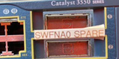 Close-up of Catalyst 3550 Series network switch ports labeled SWENAQ SPARE.