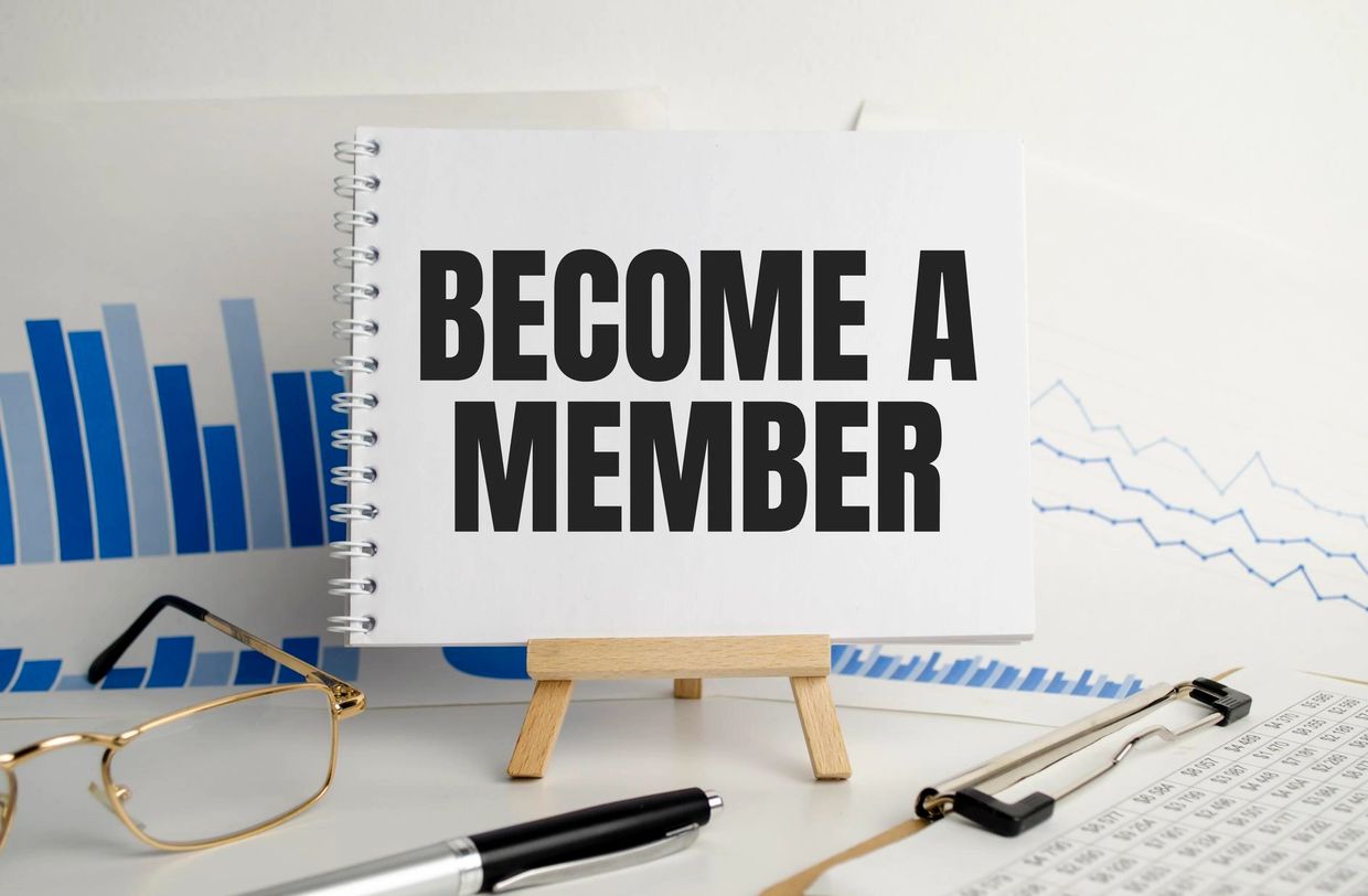 "Become a member" sign sitting on an easel with bar charts in the background.  