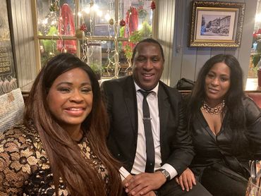 Group of people smiling into the camera at a night out.