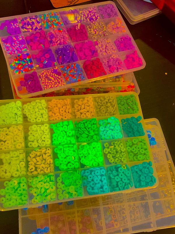 Organized trays of colorful beads sorted by color and shape.