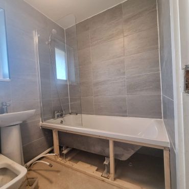 Partially installed bathtub in a bathroom under renovation.