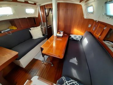 Interior cabin of the Courageous sailboat showing main seating area and cozy layout