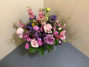 A vibrant bouquet of mixed flowers in pink, purple, and yellow hues.