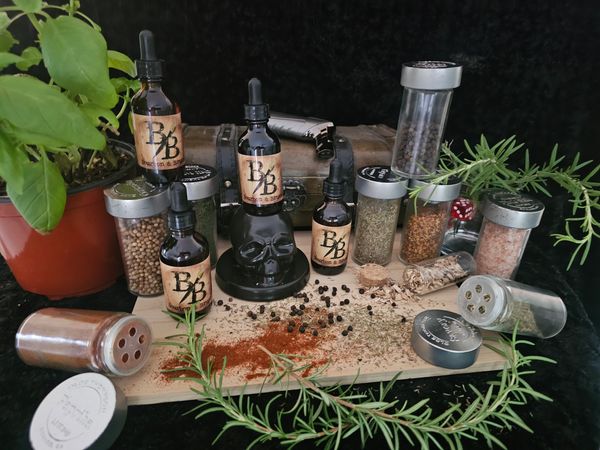 An assortment of spices and herbal bottles arranged on a wooden board with fresh herbs.